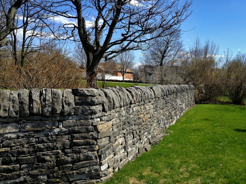 Un grand mur de soutènement avec revêtement en pierre dans le jardin